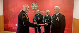 Na zdjęciu Komendant Miejski PSP w Sosnowcu wręczający decyzję o przyznaniu świadczenia ratowniczego dla strażaków OSP