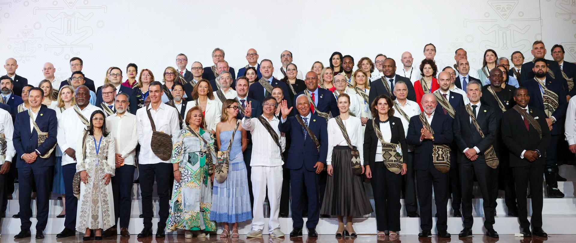 Zdjęcie grupowe polityków - 4 rzędy stojących osób, mężczyźni najczęściej w garniturach, kobiety w sukienkach.