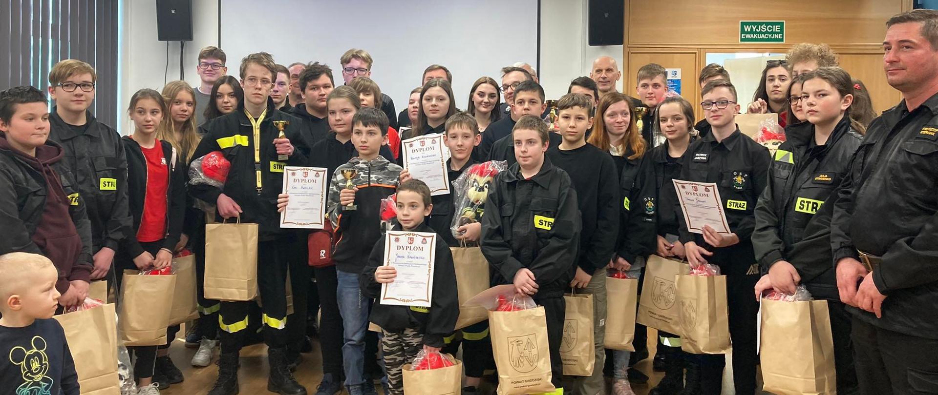 Uczestnicy powiatowych eliminacji Ogólnopolskiego Turnieju Wiedzy Pożarniczej pozują do wspólnego zfjęcia.