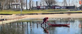 Na zdjęciu widać strażaka z saniami lodowymi na zamarzniętym akwenie.