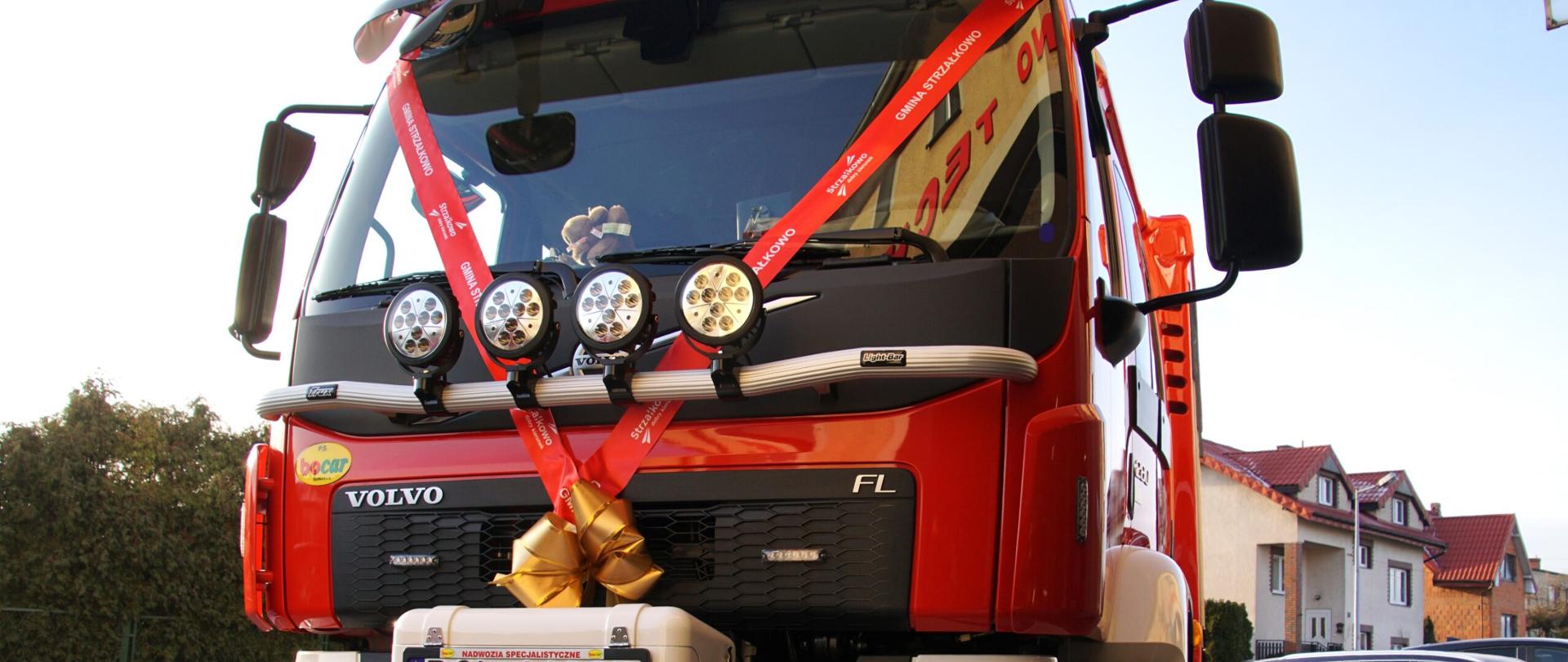 samochód ratowniczo gaśniczy stoi na placu przybrany wasążkami