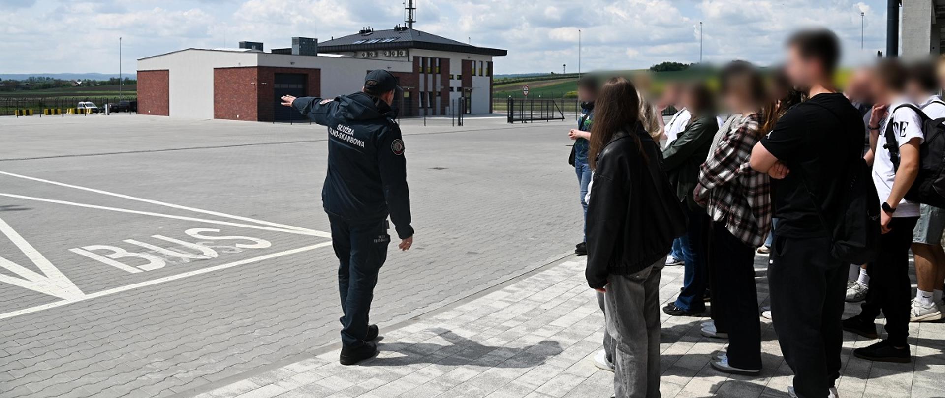 Wizyta studentów na przejściu granicznym w Malhowicach. Funkcjonariusz prezentuje studentom przejście graniczne.