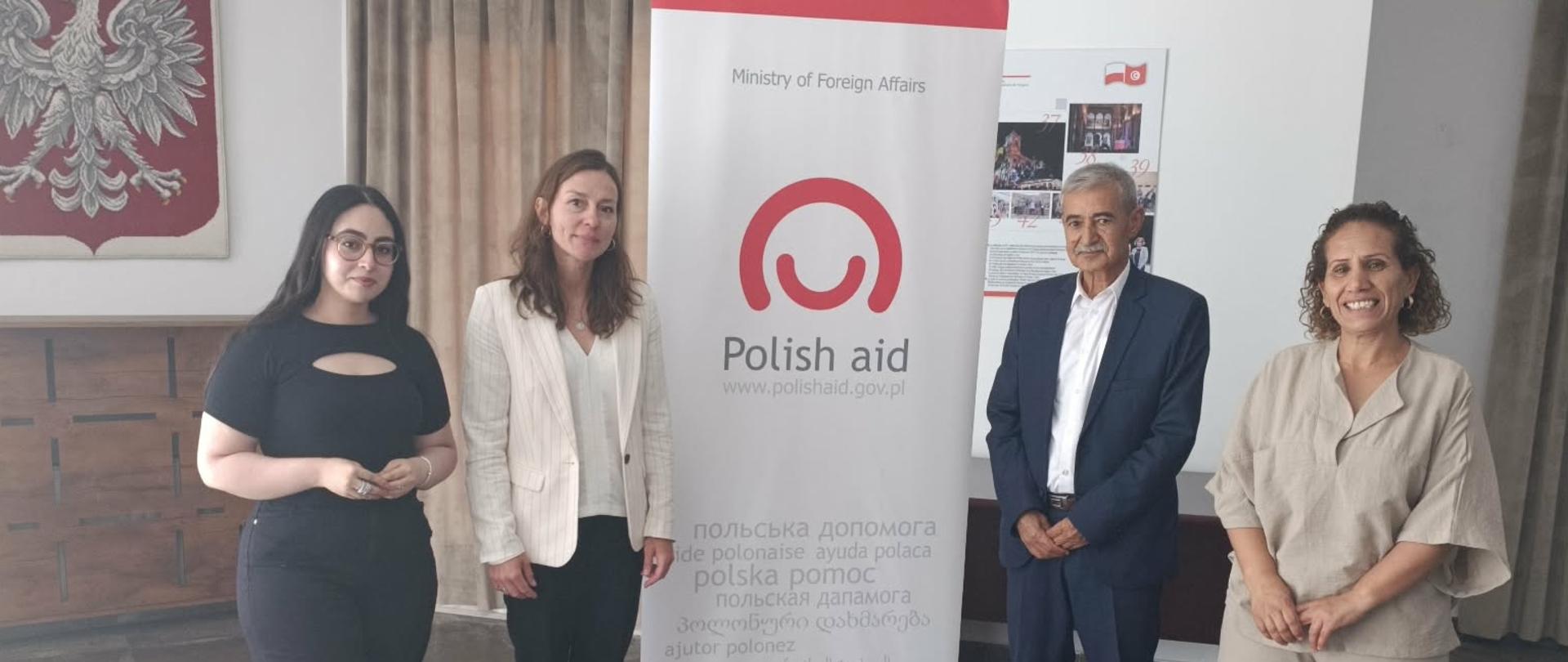 3 kobiety i mężczyzna na tle logo Polish Aid