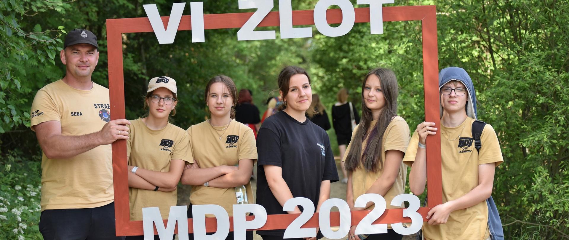 Na zdjęciu znajduje się młodzieżowa drużyna pożarnicza z szyldem VI Zlot MDP 2023