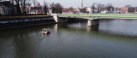 Łódka z ratownikami na rzece w tle most