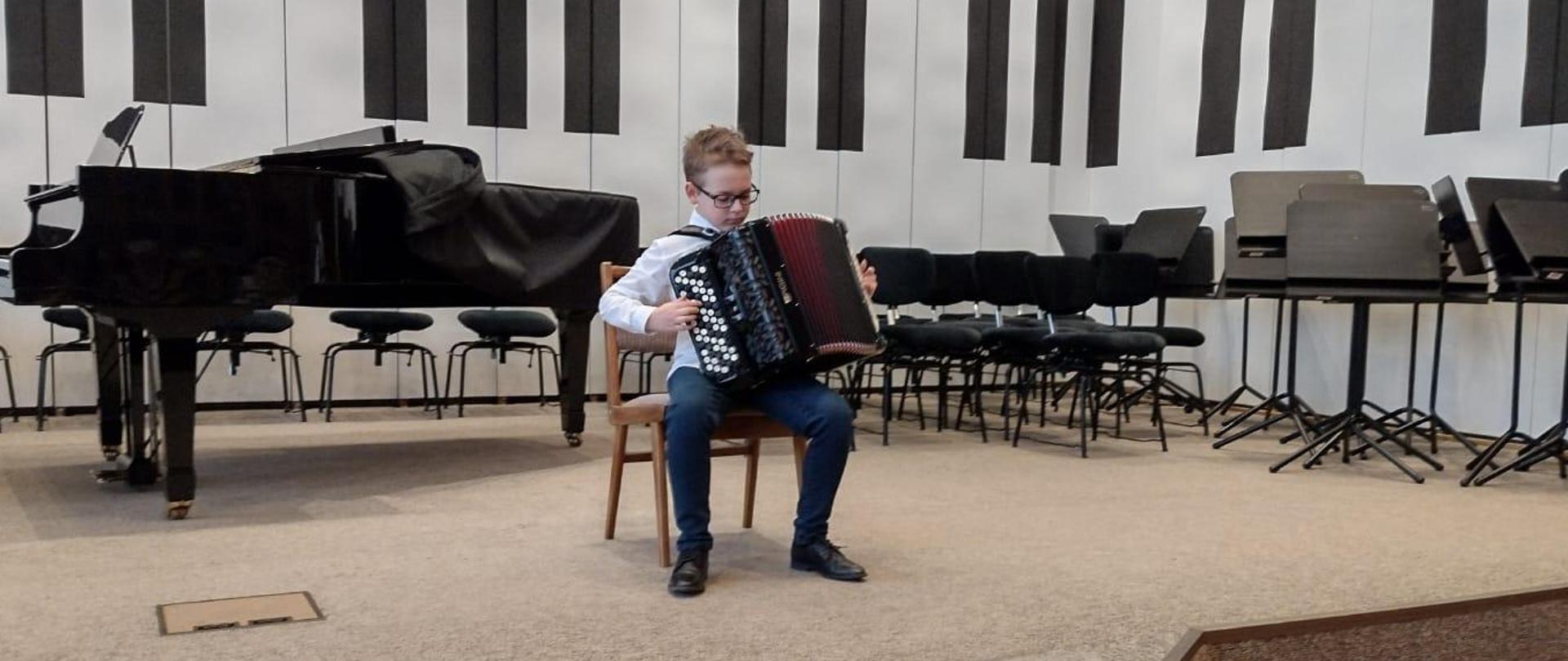 Chłopiec gra na akordeonie.