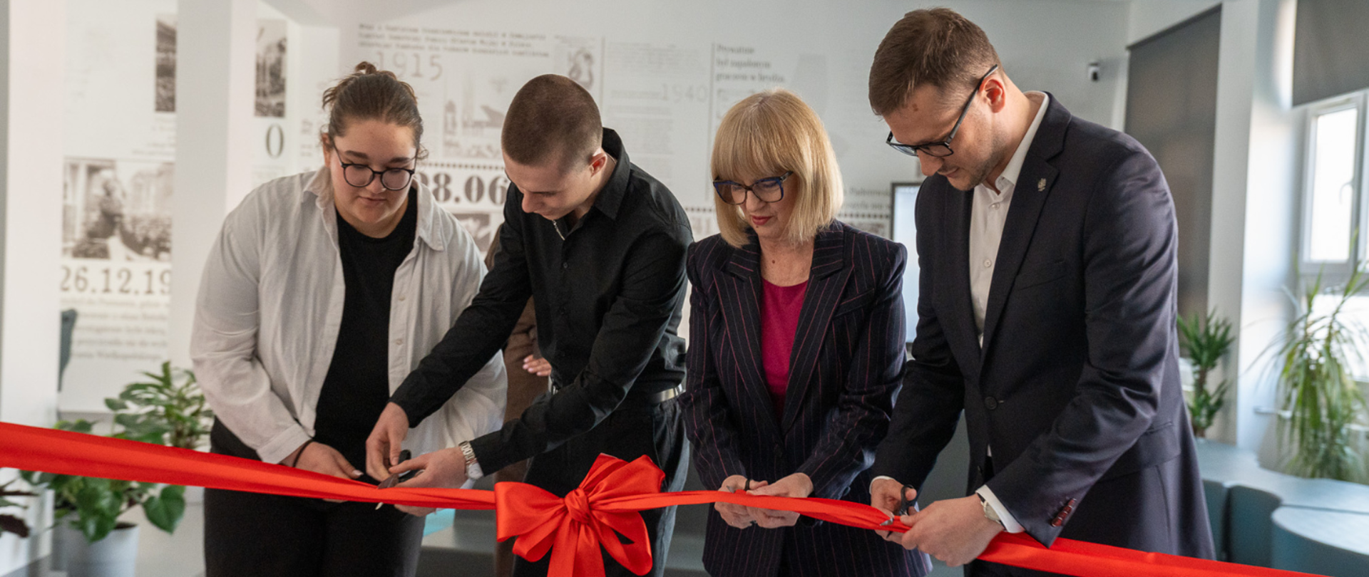 Wojewoda Kujawsko-Pomorski Michał Sztybel, wraz Iwoną Waszkiewicz zastępcą Prezydenta Bydgoszczy i uczniami, uroczyście przecina czerwoną wstęgę, otwierając zmodernizowaną przestrzeń świetlicy szkolnej. Zdjęcie przedstawia fragment odnowionego wnętrza.