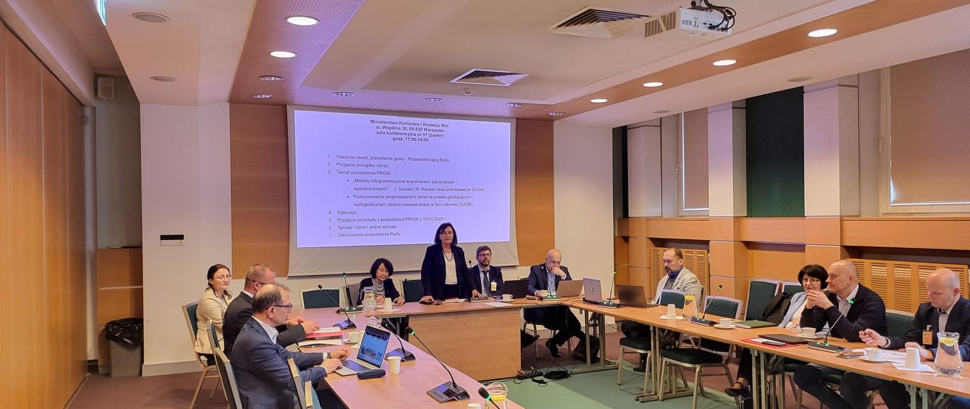 Zdjęcie przedstawia członków Państwowej Rady Geodezyjnej i Kartograficznej podczas posiedzenia.