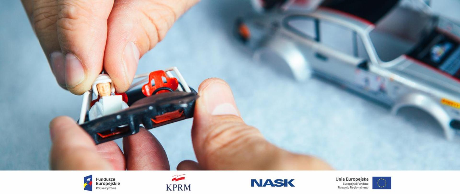 ręce wkładają ludzika do zabawkowego samochodzika