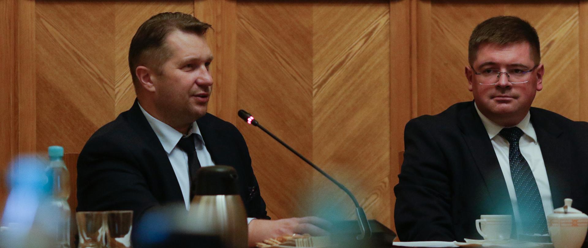 Spotkanie inaugurujące działalność Zespołu do spraw wsparcia młodzieżowych drużyn pożarniczych, przemawia minister Przemysław Czarnek, obok siedzi wiceminister Tomasz Rzymkowski.