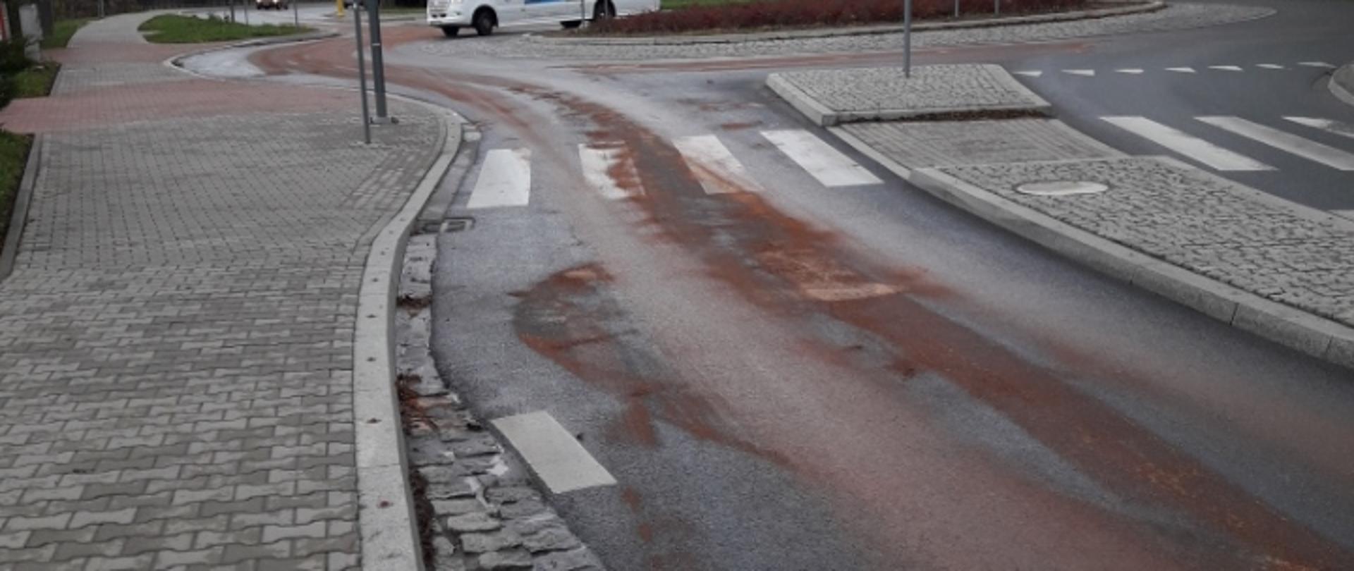 Na zdjęciu jezdnia na której znajduje się plama oleju zasypana sorbentem