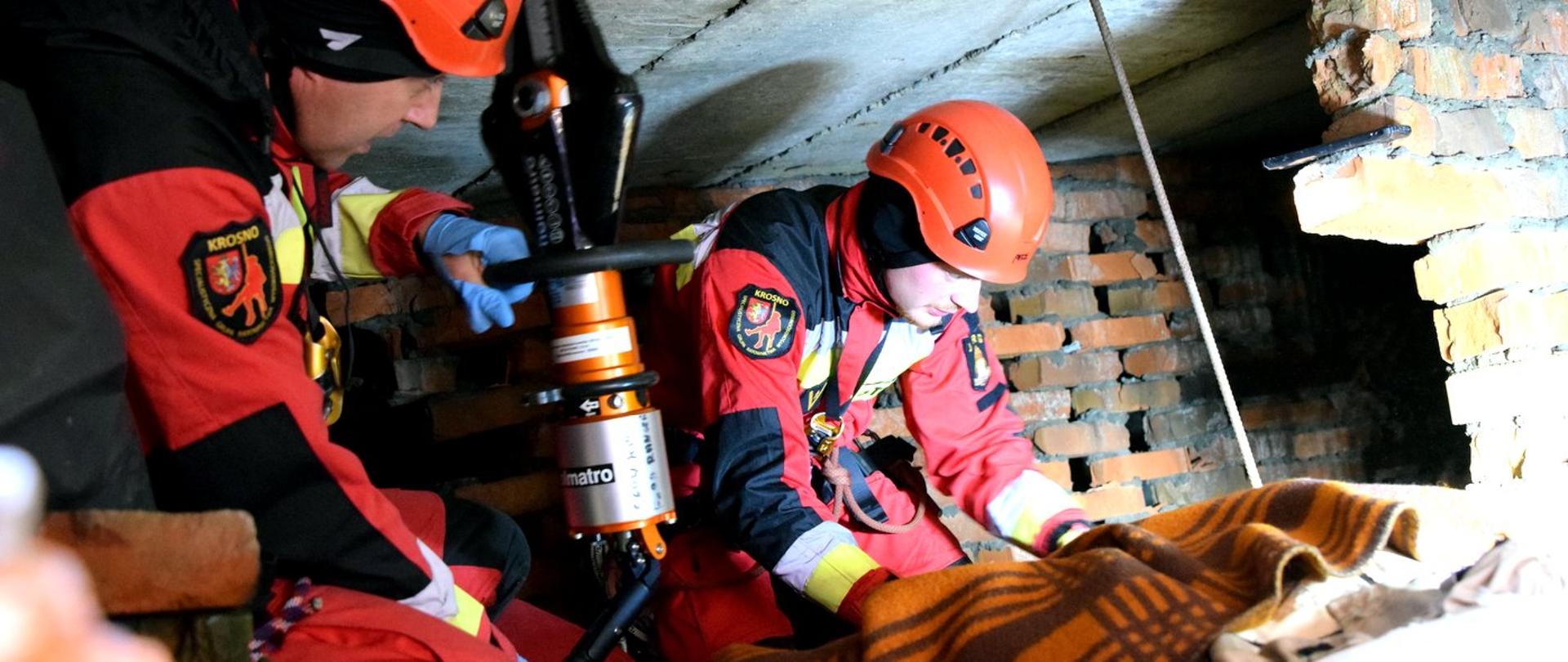 Zdjęcie zrobione na zewnątrz podczas ćwiczeń strażaków PSP i OSP. Strażacy realizują założone elementy ćwiczeń