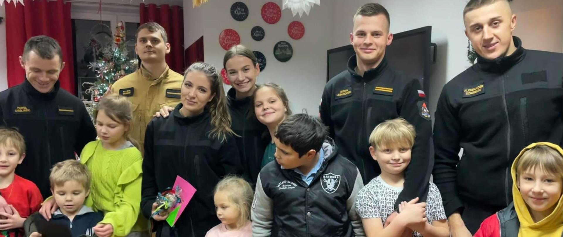 Pamiątkowe zdjęcie dzieci z domu dziecka (8 dzieci) wraz z dwiema kadetkami i czterema kadetami Centralnej Szkoły PSP