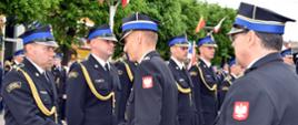 Widok z boku. Zastępca małopolskiego komendanta wojewódzkiego PSP w trakcie wręczania strażakom PSP aktów mianowania na wyższe stopnie służbowe.