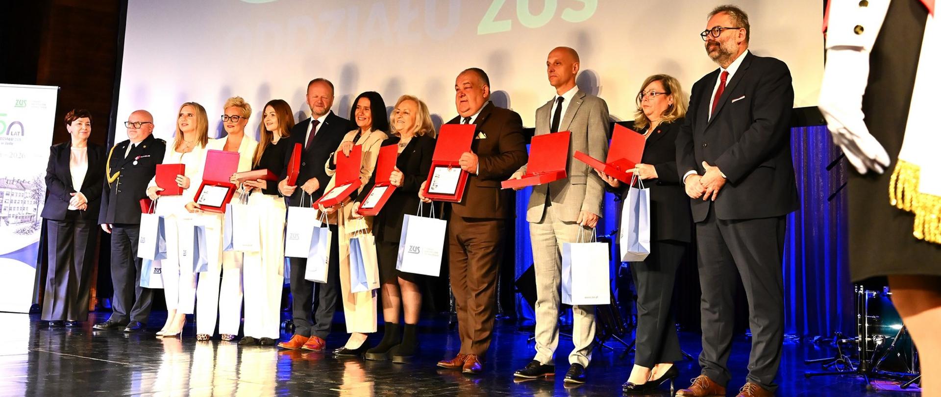 Uczestnicy jubileuszu z różnych instytucji, w tym IAS w Rzeszowie stoją na scenie.
