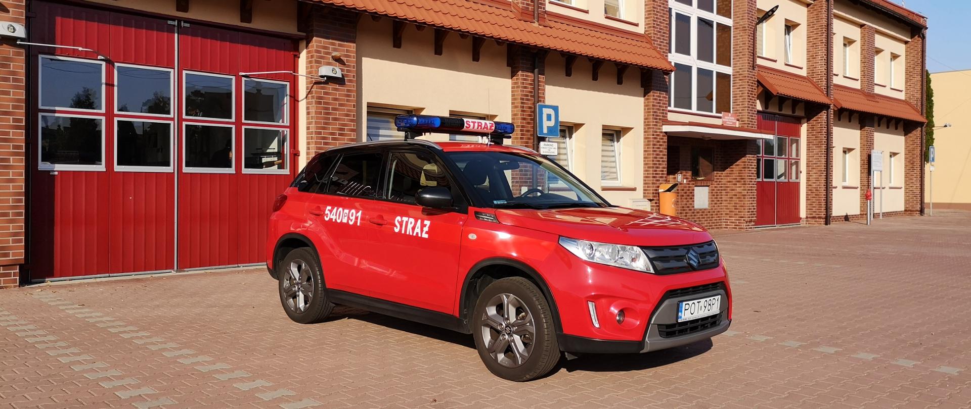 Na zdjęciu samochód specjalny lekki operacyjny Suzuki Vitara na placu manewrowym przed garażami Jednostki Ratowniczo-Gaśniczej