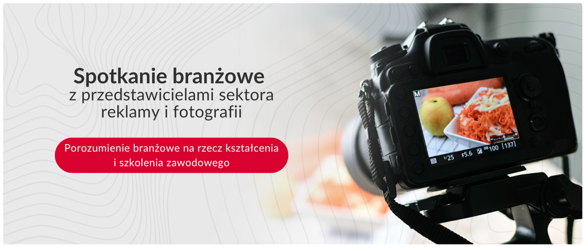 Grafika z napisem „Spotkanie branżowe z przedstawicielami sektora reklamy i fotografii” oraz czerwonym przyciskiem „Porozumienie branżowe na rzecz kształcenia i szkolenia zawodowego”. Po prawej stronie widać tył aparatu fotograficznego na statywie, na którego ekranie wyświetla się podgląd zdjęcia potrawy.