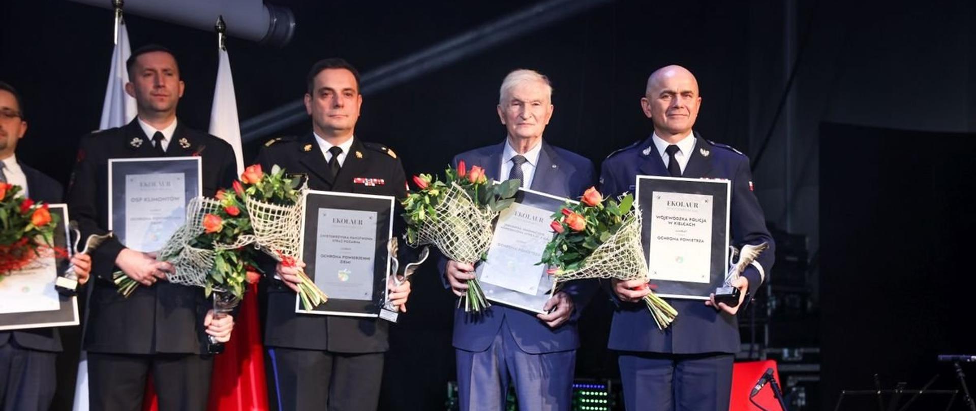 Na zdjęciu widzimy pozujących do zdjęcia laureatów ekolaur. W tym drugi od lewej strażacki generał.
