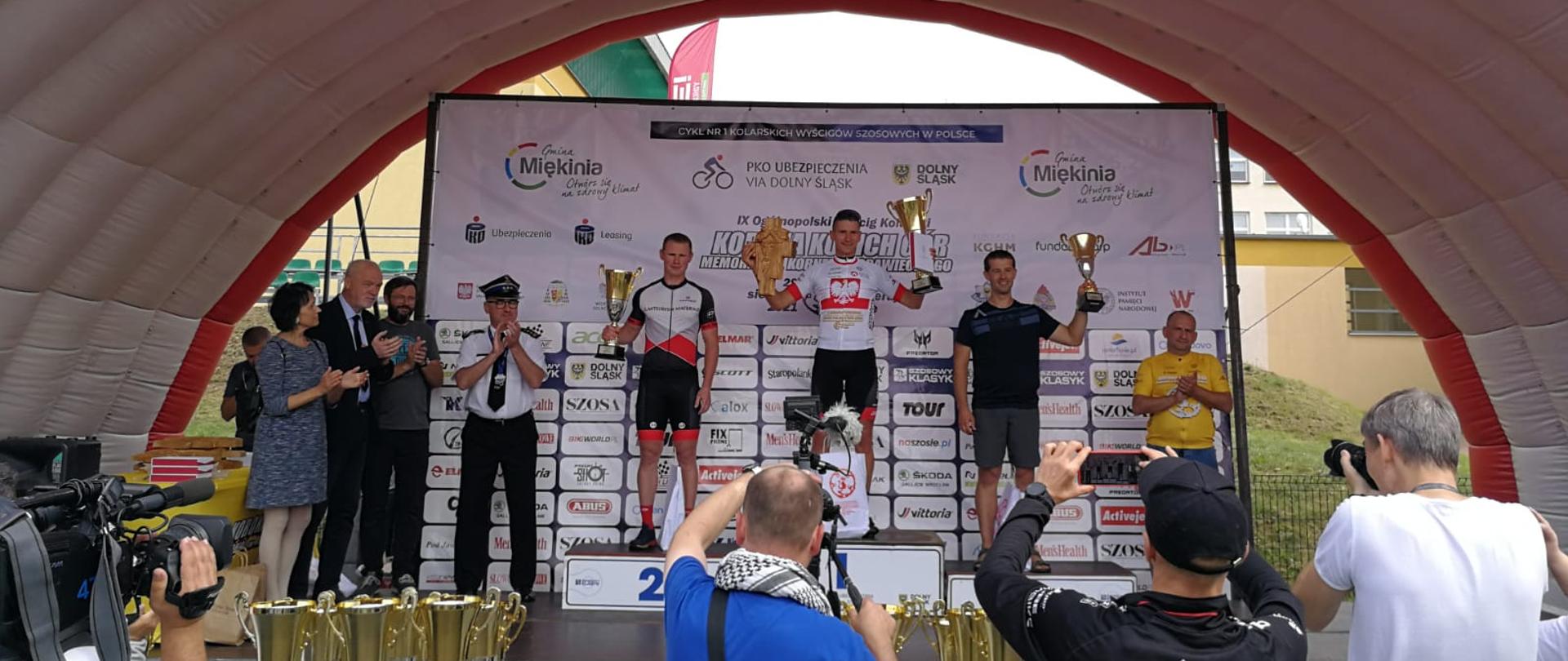 na zdjęciu widać podium ze strażakami, którzy zajęli pierwsze trzy miejsca w wyścigu kolarskim