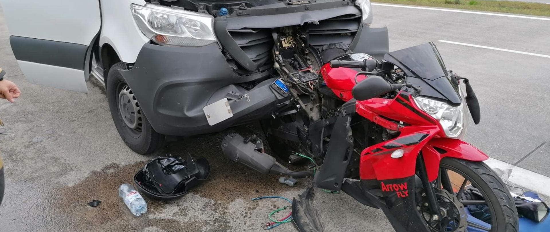 Dzień. Tył motocykla wbity w przód busa.