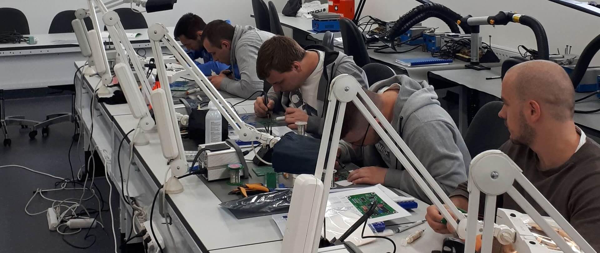 Grupa studentów pracuje przy inżynierskim stole warsztatowym