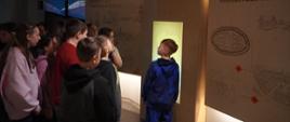 Dzieci oglądają wystawę. Przed nimi multimedialna ściana edukacyjna. 