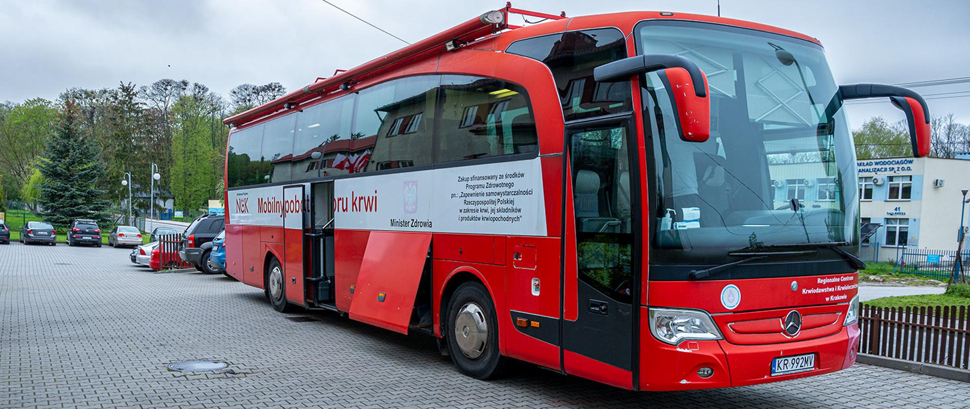 Na zdjęciu widoczny mobilny autobus do pobrań krwi zaparkowany przed Komendą Powiatowa PSP w Miechowie