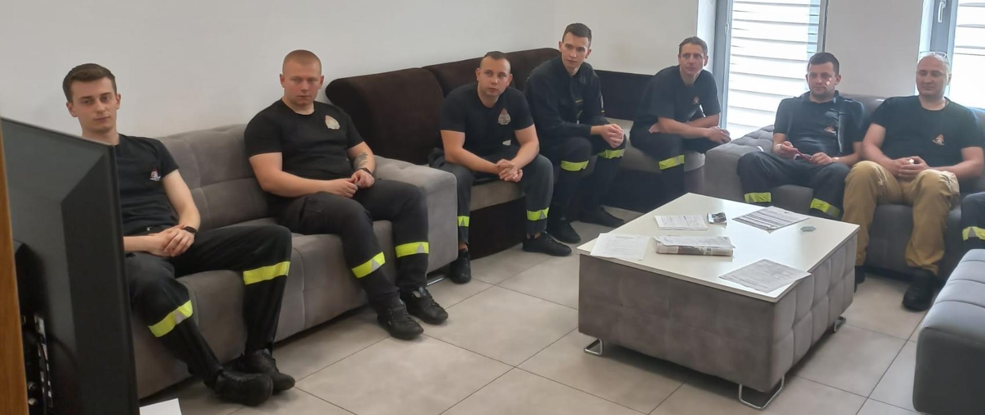 Zdjęcie przedstawia siedmiu strażaków siedzących podczas szkolenia 