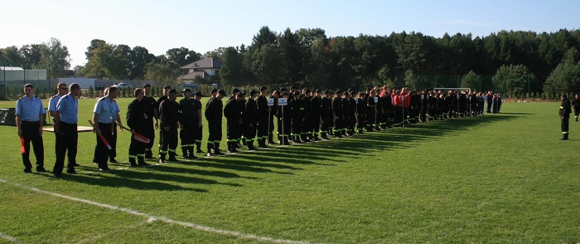 Zdjęcie przedstawia zbiórkę zawodników na boisku