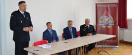 Zdjęcie przedstawia Komendanta Powiatowego PSP w Ropczycach Witolda Wierciocha w umundurowaniu wyjściowym przemawiającego do zebranych druhów strażaków oraz zaproszonych gości w sali Powiatowego Centrum Edukacji Kulturalnej w Ropczycach