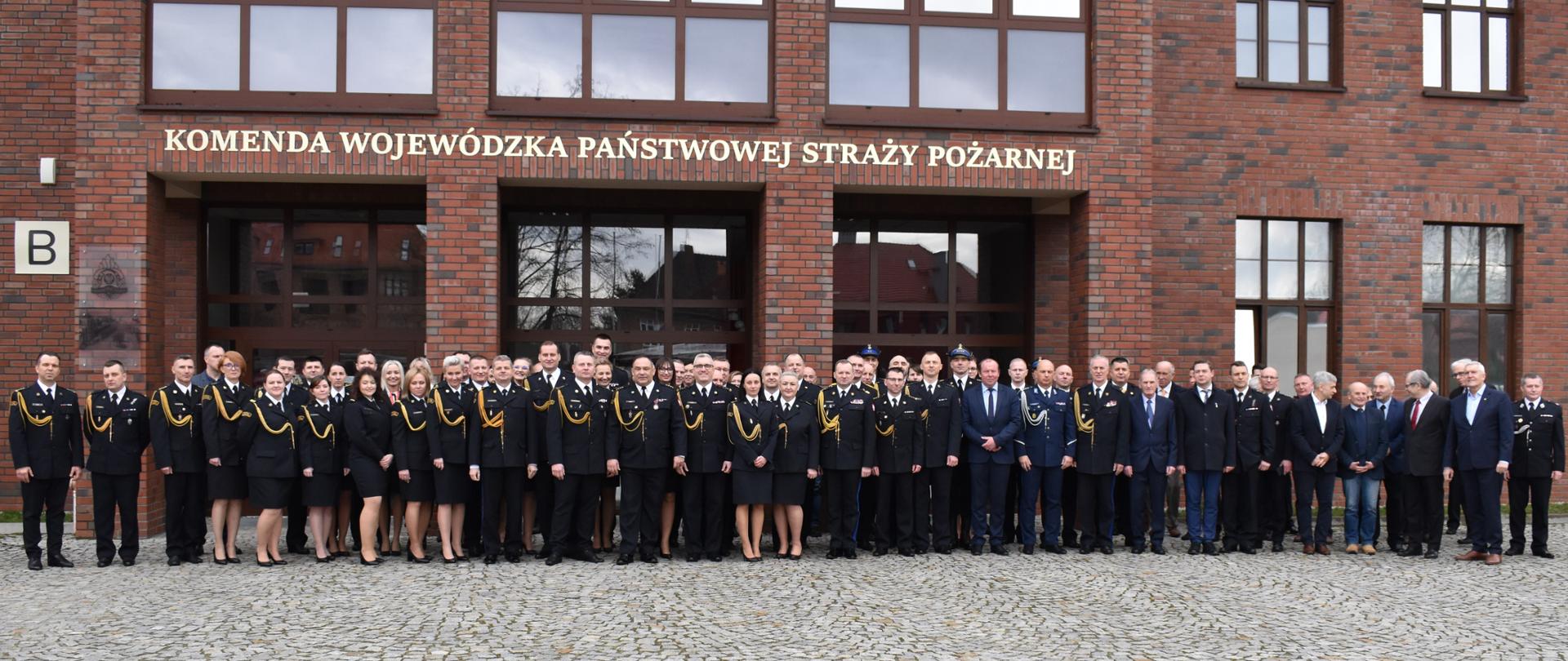 Zdjęcie grupowe strażaków przed budynkiem KW PSP Wrocław 