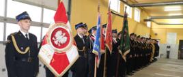 Poczty sztandarowe oraz strażacy ubrani w mundury galowe podczas uroczystej zbiórki