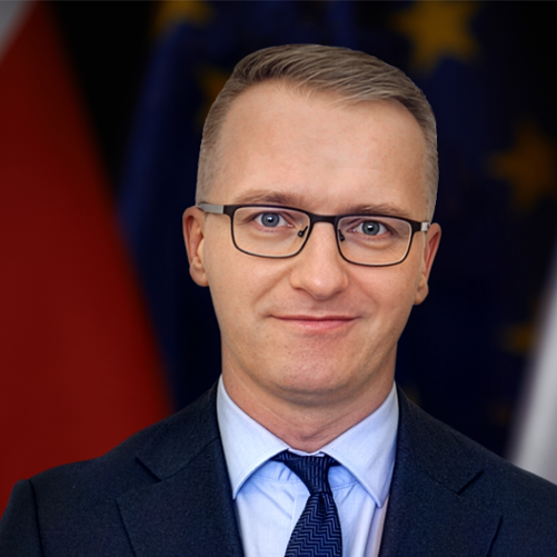 Dyrektor generalny MSiT Piotr Kudelski na tle flag polskiej i UE