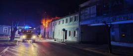 Zdjęcie pokazujące strażaków podczas akcji gaśniczej. Jest noc. 