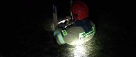 Strażak ratownik sprawia drabinę nasadkowa aby wejść do studni gdzie znajduje się uwieziona sarna