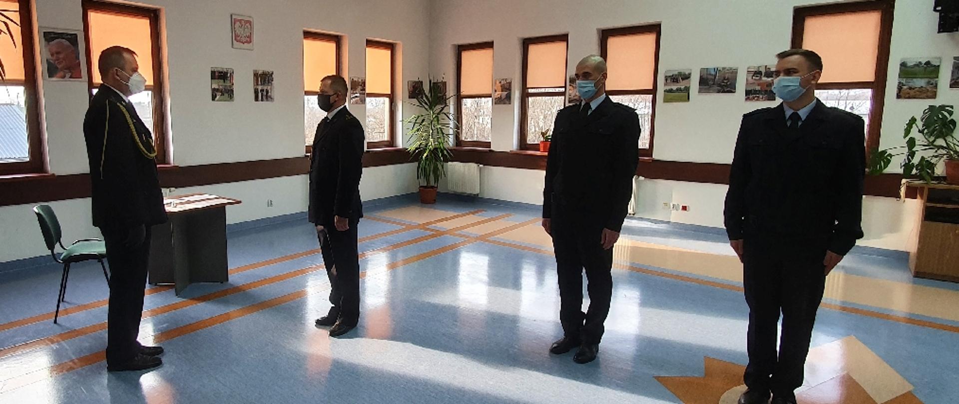 W sali konferencyjnej Komendy Powiatowej Państwowej Straży Pożarnej w Sokołowie Podlaskim 4 funkcjonariuszy rozpoczyna uroczystość.