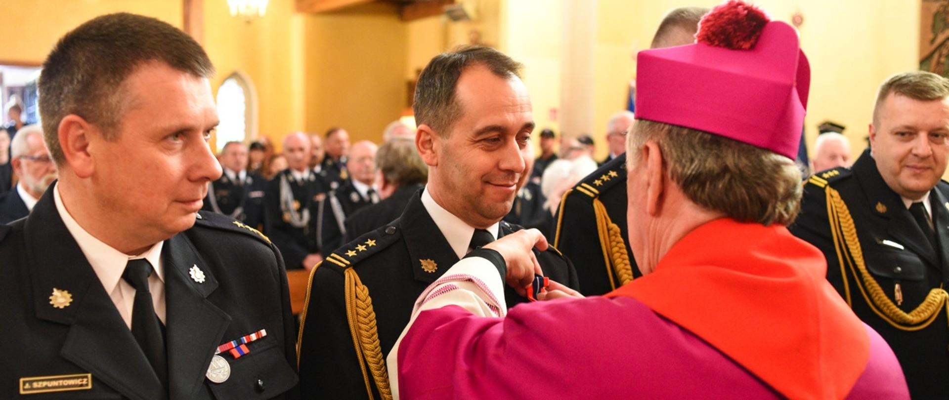 Arcybiskup wręczający odznaczenia