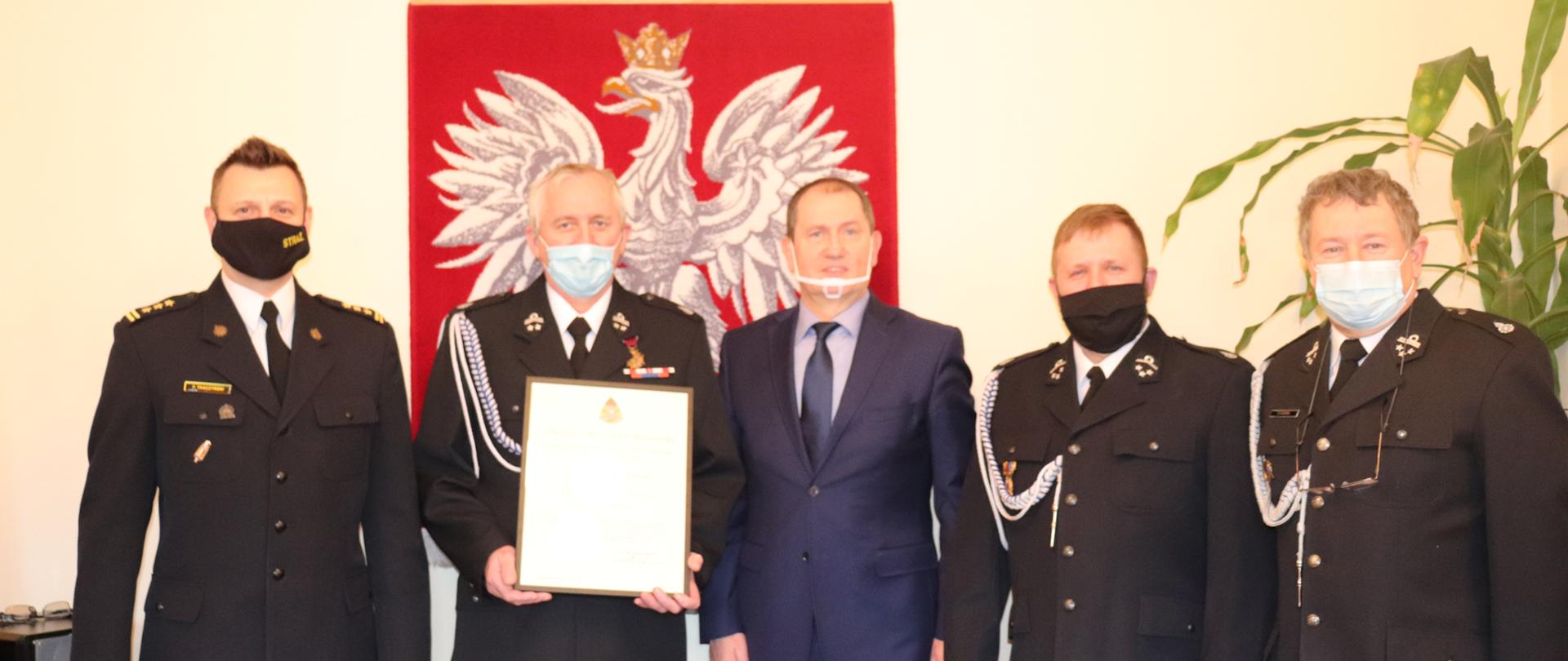 Zdjęcie przedstawia Komendanta Powiatowego PSP st. bryg. Piotra Tkaczyńskiego, Wójta Gminy Osie Pana Michała Grabskiego, Prezesa OSP Miedzno dh Andrzeja Czerwińskiego, Naczelnika dh Sebastiana Konopackiego oraz Zastępcy Naczelnika dh Mirosława Nagórskiego prezentujących akt włączenia do Krajowego Systemu Ratowniczo-Gaśniczego.