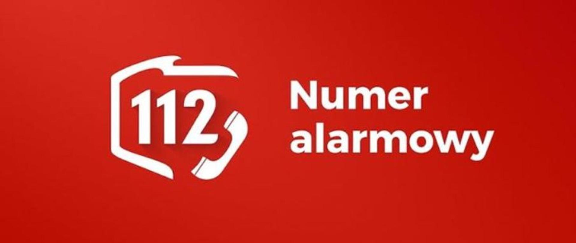 Zdjęcie przedstawia napis numer alarmowy oraz numer 112 na czerwonym tle. Numer telefonu 112 znajduje się w obwódce przypominającej kształt terytorium RP, a w prawym dolnym roku numeru 112 znajduje się słuchawka telefoniczna.