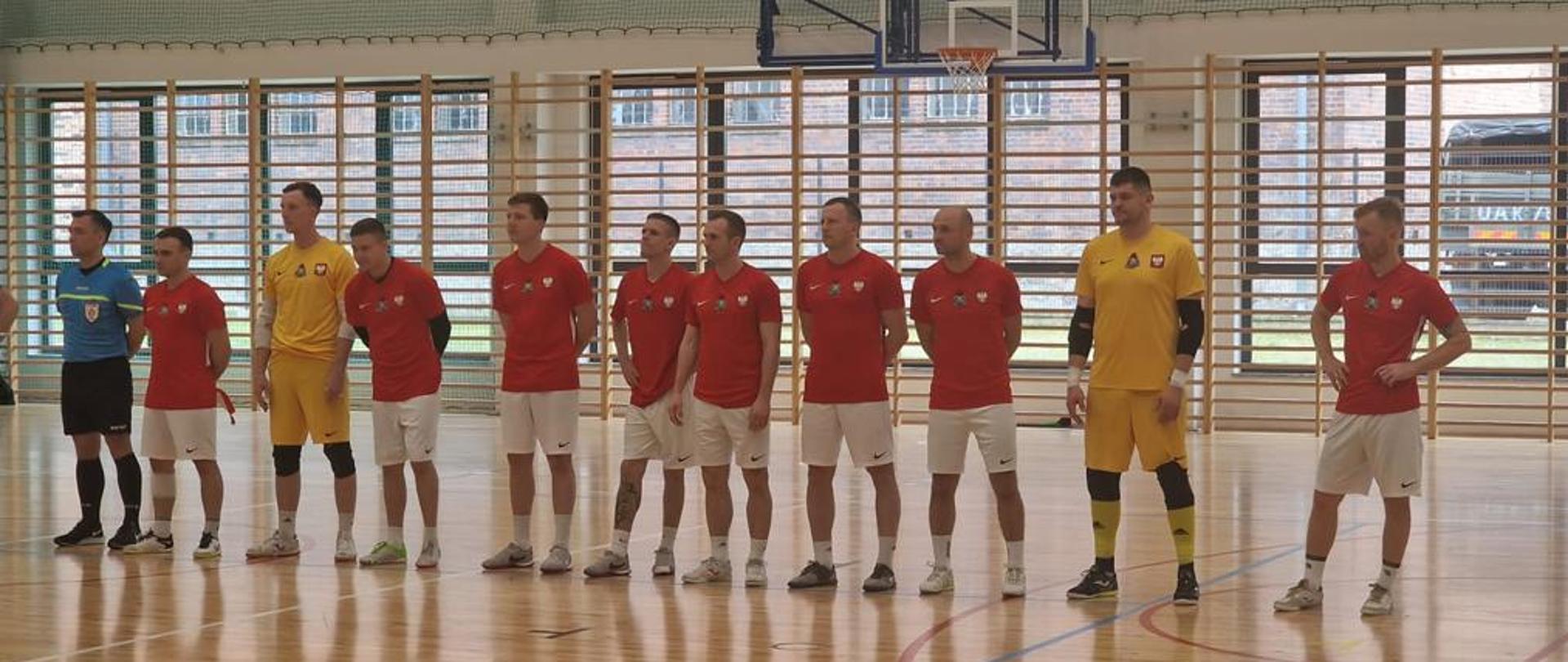 Prezentacja drużyny przed meczem. Dziesięciu zawodników oraz sędzia z lewej strony