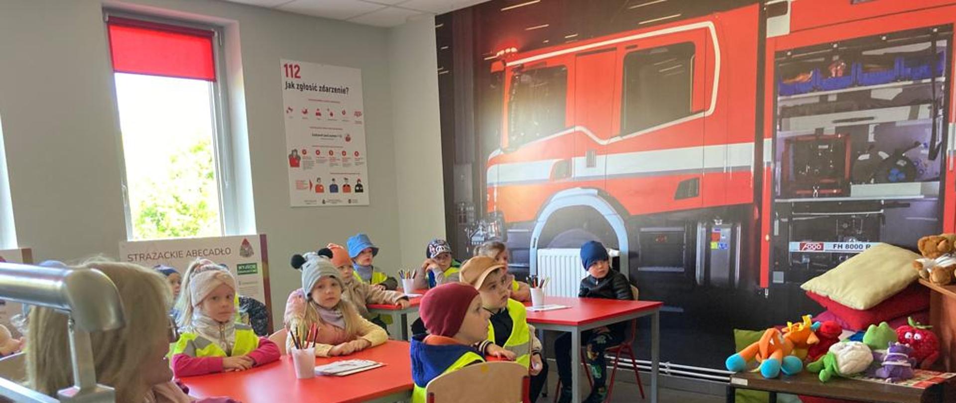 Na zdjęciu dzieci przy stolikach na salce edukacyjnej