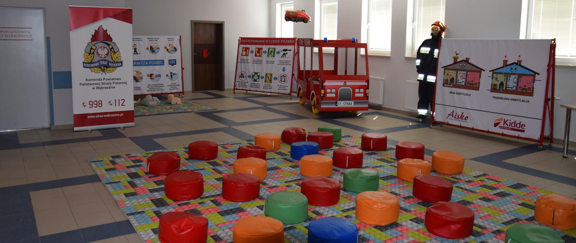 Zdjęcie przedstawia salę edukacyjną, przygotowaną na przyjęcie dzieci na zajęcia. Kolorowe siedziska, pomoce edukacyjne...