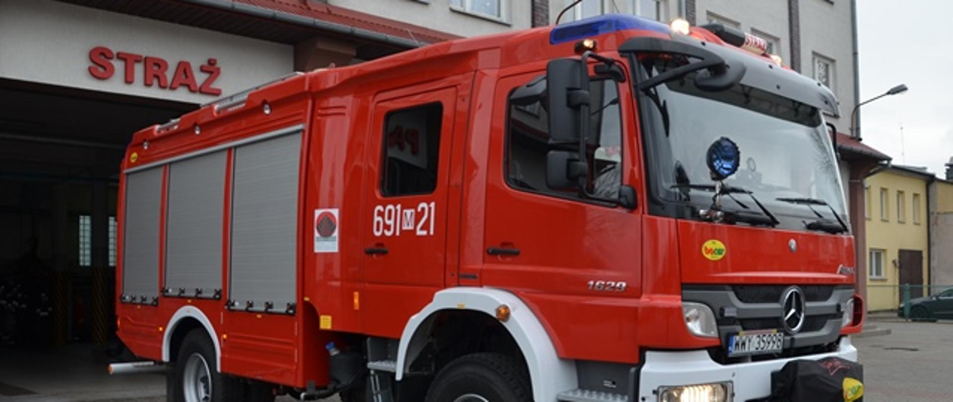 Pojazd strażacki na tle Komendy Powiatowej PSP