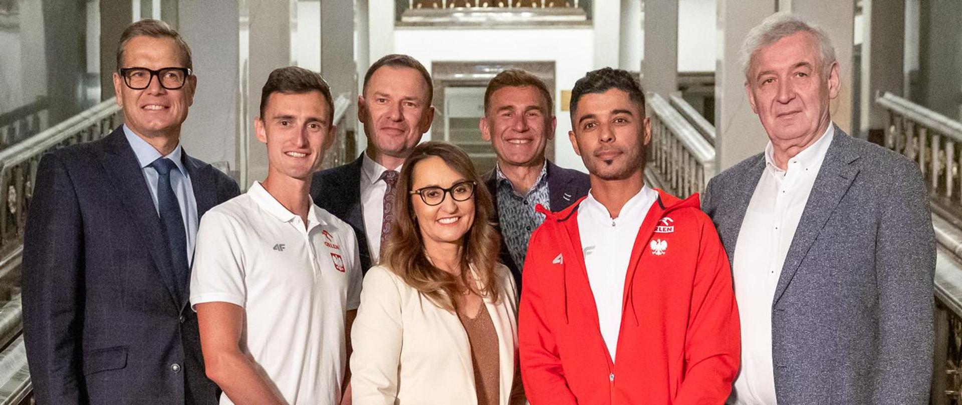 Zdjęcie grupy ludzi na schodach wewnątrz Teatru Wielkiego - Opery Narodowej w Warszawie. Od lewej w tylnym rzędzie: Sebastian Chmara – wiceprezes Polskiego Związku Lekkiej Atletyki; Piotr Borys – wiceminister sportu i turystyki; Robert Korzeniowski – chodziarz, czterokrotny mistrz olimpijski, trzykrotny mistrz świata i dwukrotny mistrz Europy; Waldemar Dąbrowski – dyrektor Teatru Wielkiego – Opery Narodowej w Warszawie. Z przodu od lewej: Dawid Tomala – chodziarz, mistrz olimpijski z Tokio w chodzie na 50 kilometrów; Renata Kaznowska – zastępca prezydenta m.st. Warszawy i Maher Ben Hlima – chodziarz pochodzenia tunezyjskiego, reprezentujący Polskę. Fot. Tomasz Kasjaniuk