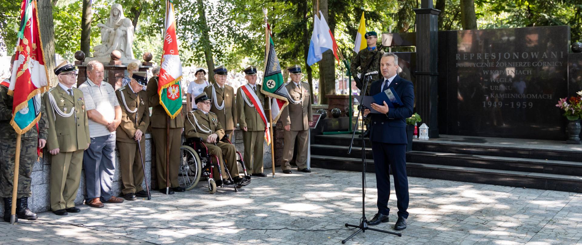 Wojewoda przemawia podczas uroczystości, wokół zgromadzeni kombatanci 