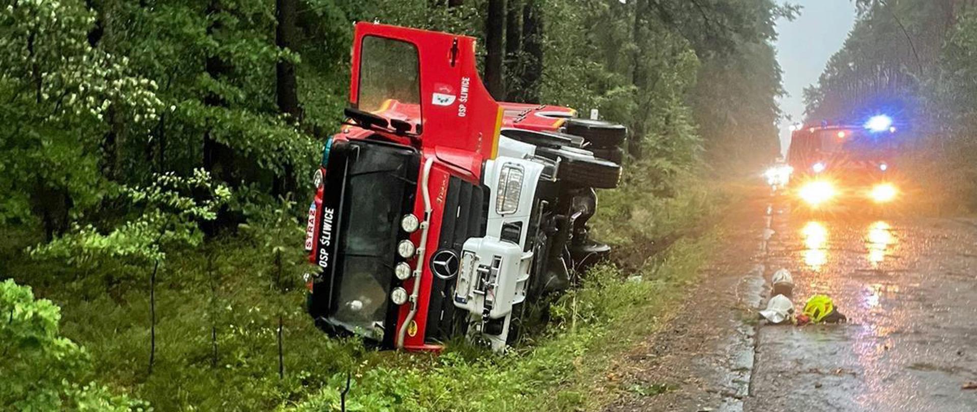 Samochód straży pożarnej uległ wypadkowi i znajduje się poza drogą. 