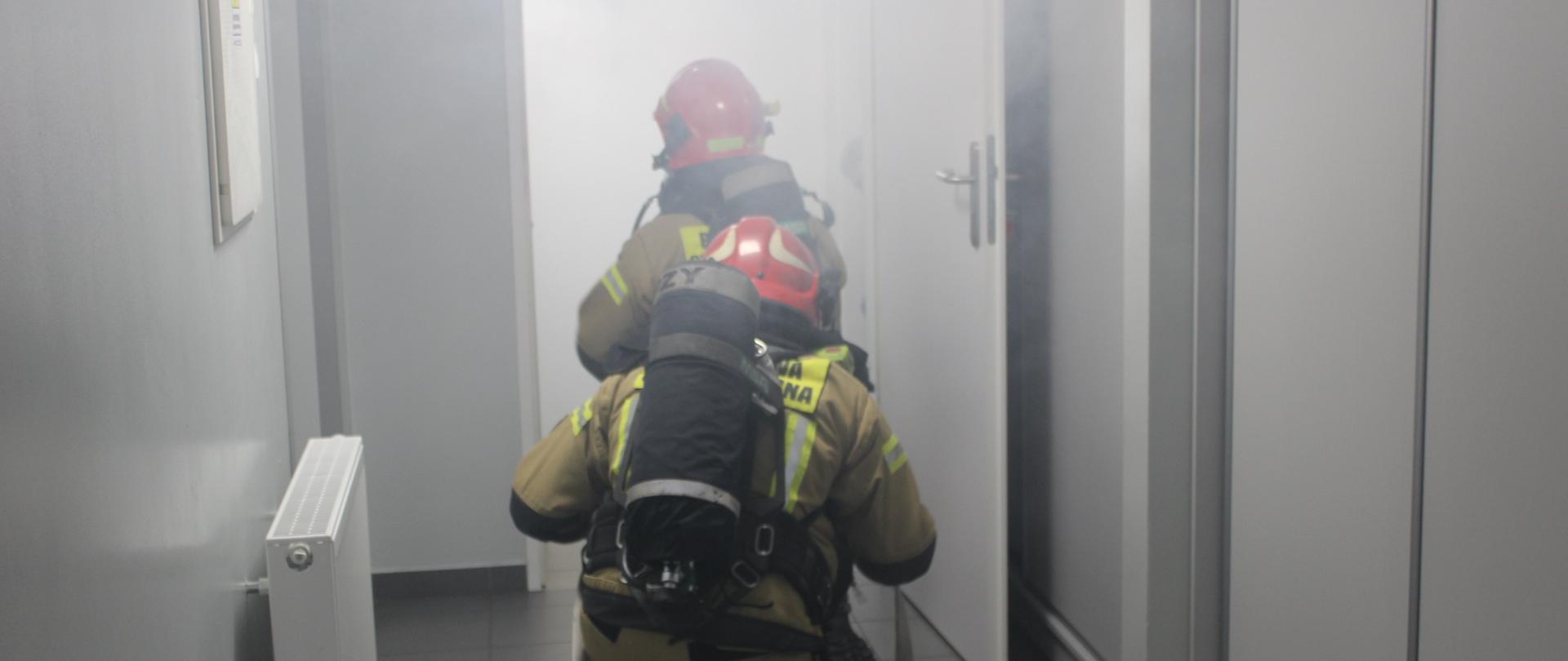 Strażacy przed wejściem do zadymionego pomieszczenia podczas symulowanej akcji ratowniczo-gaśniczej w SP ZOZ w Bielsku Podlaskim.