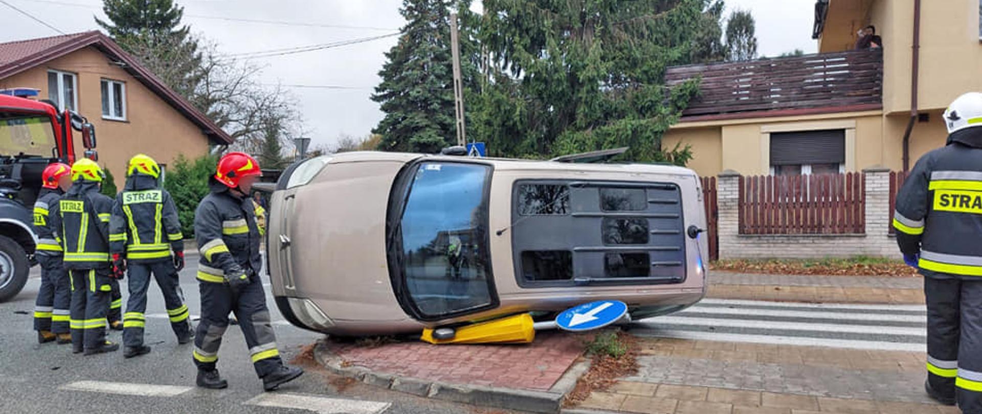 wrak samochodu osobowego leżący na boku przy przejściu dla pieszych