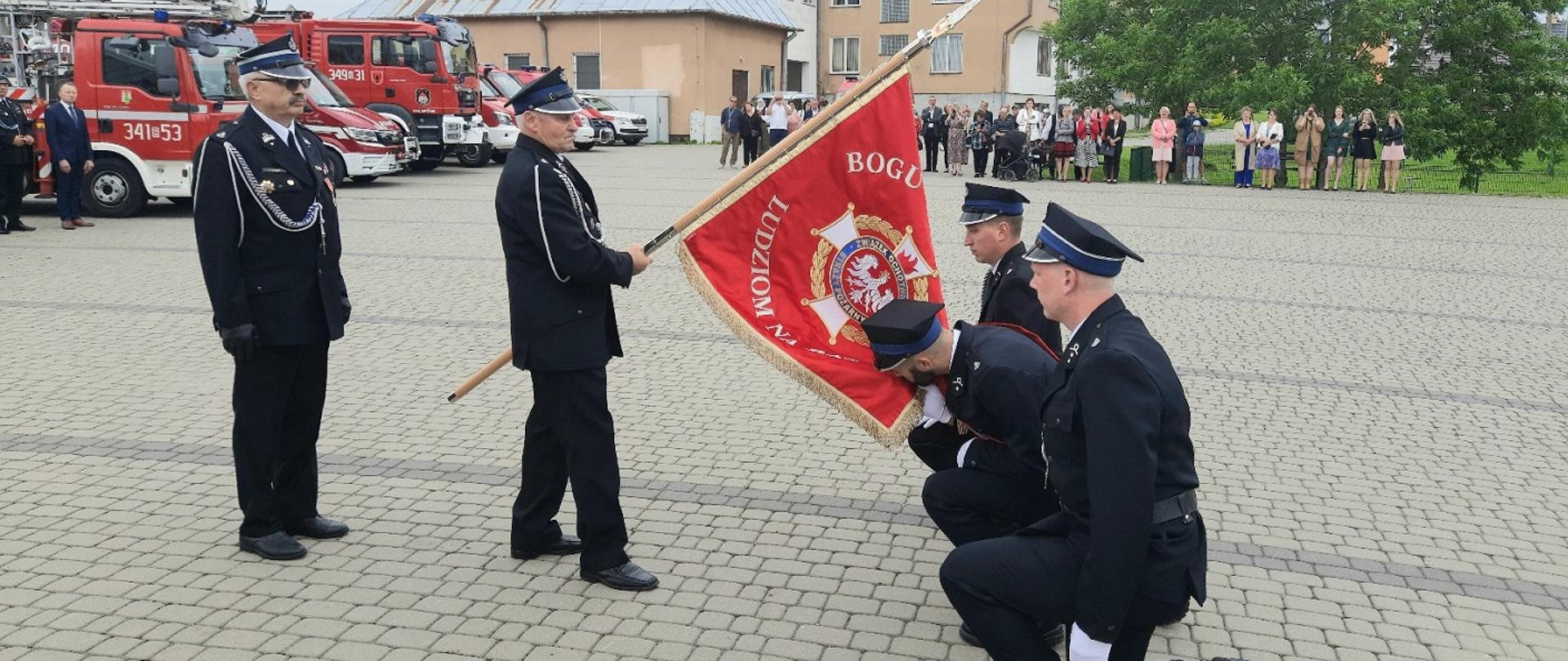 Zdjęcie obrazuje strażaków ze sztandarem