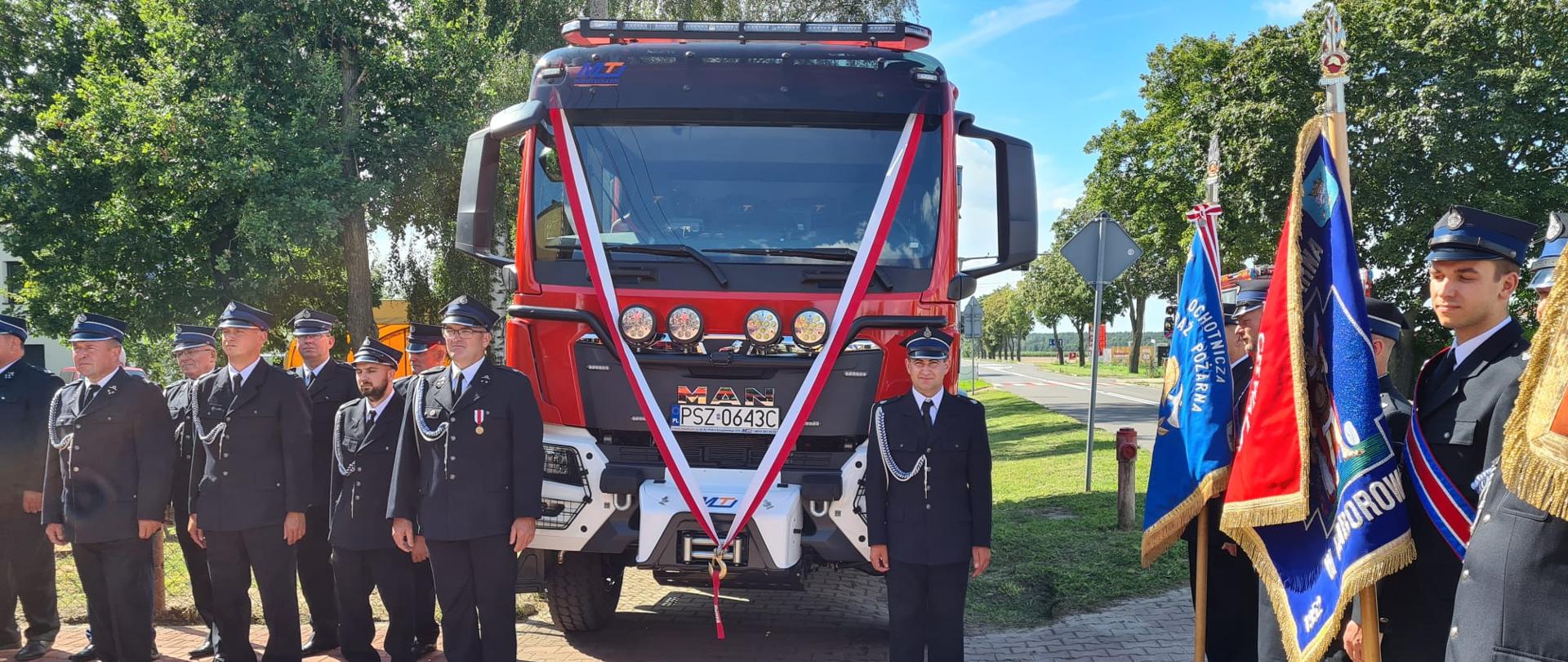 Nowy samochód marki MAN, po lewej i prawej strażacy